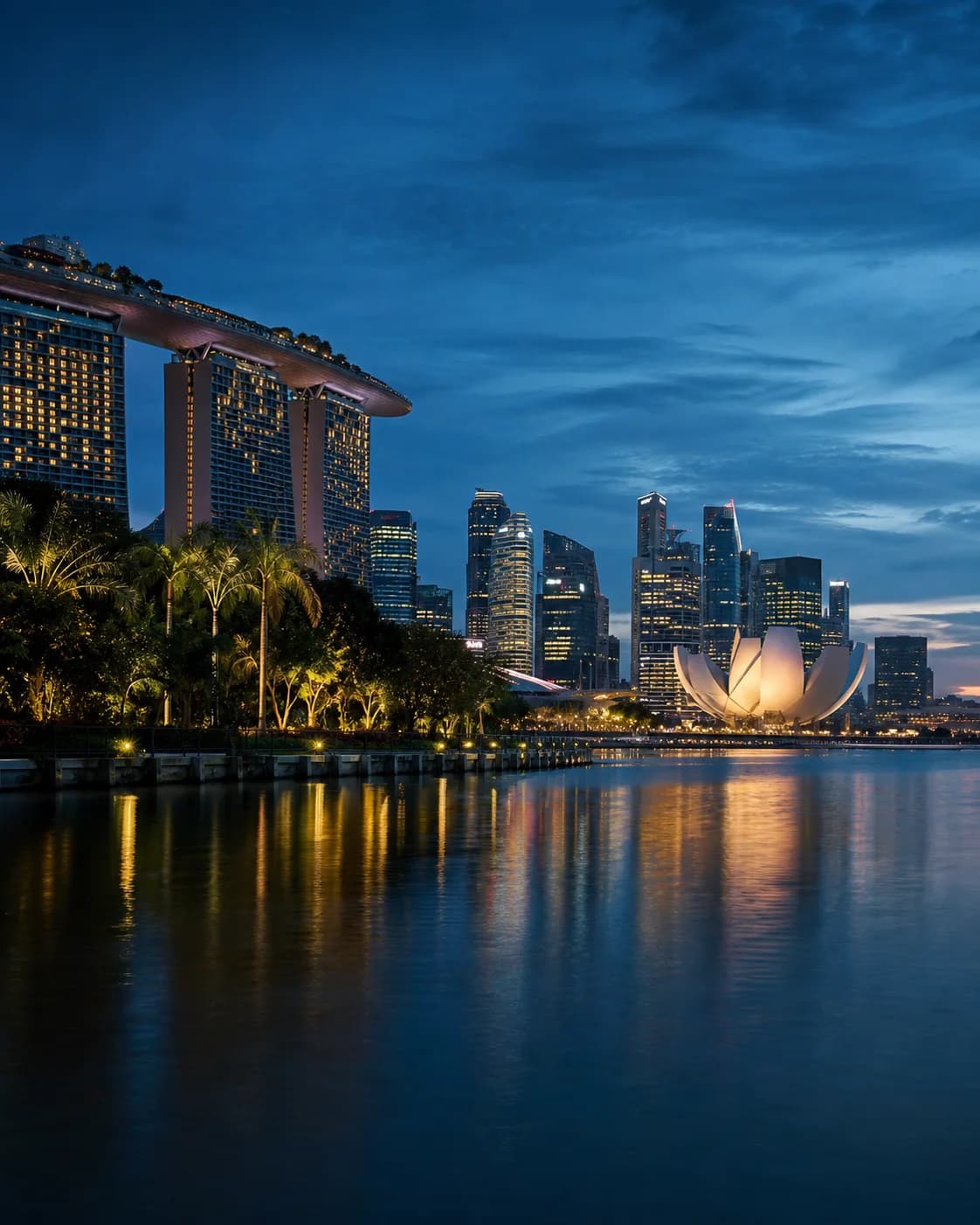Singapore's Marina Bay waterfront and skyline glowing at blue hour
